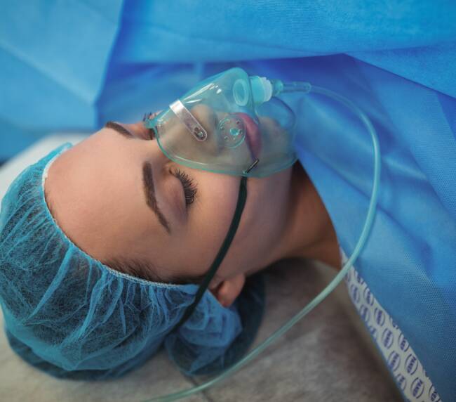 Female patient with oxygen mask in operation theater