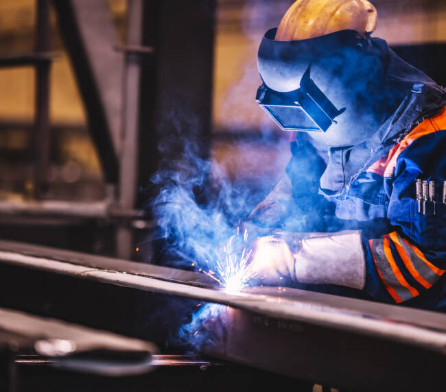 Worker welding in a factory.